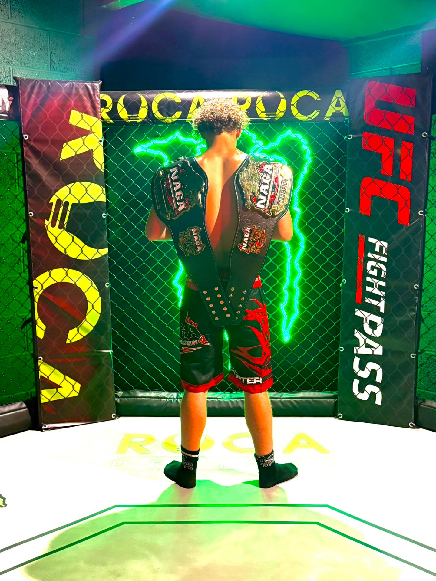 Inside the cage holding two championship belts